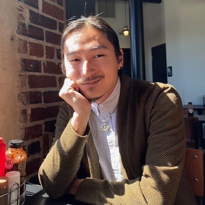 UConn Grad Student Jacob Finegan smiling in front of a brick wall
