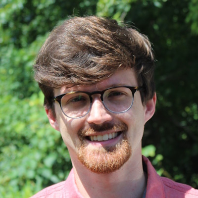 Image of Professor Henry Snow, a young white man with brown hair, glasses, and a mustache and goatee.