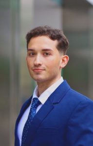 Lucas Ruiz, class of 2023. Mr. Ruiz is a young man with brown hair in a blue suit and tie with a white shirt.