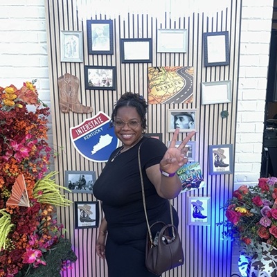 PhD student Veronica Primm smiling and making a peace sign with her hand